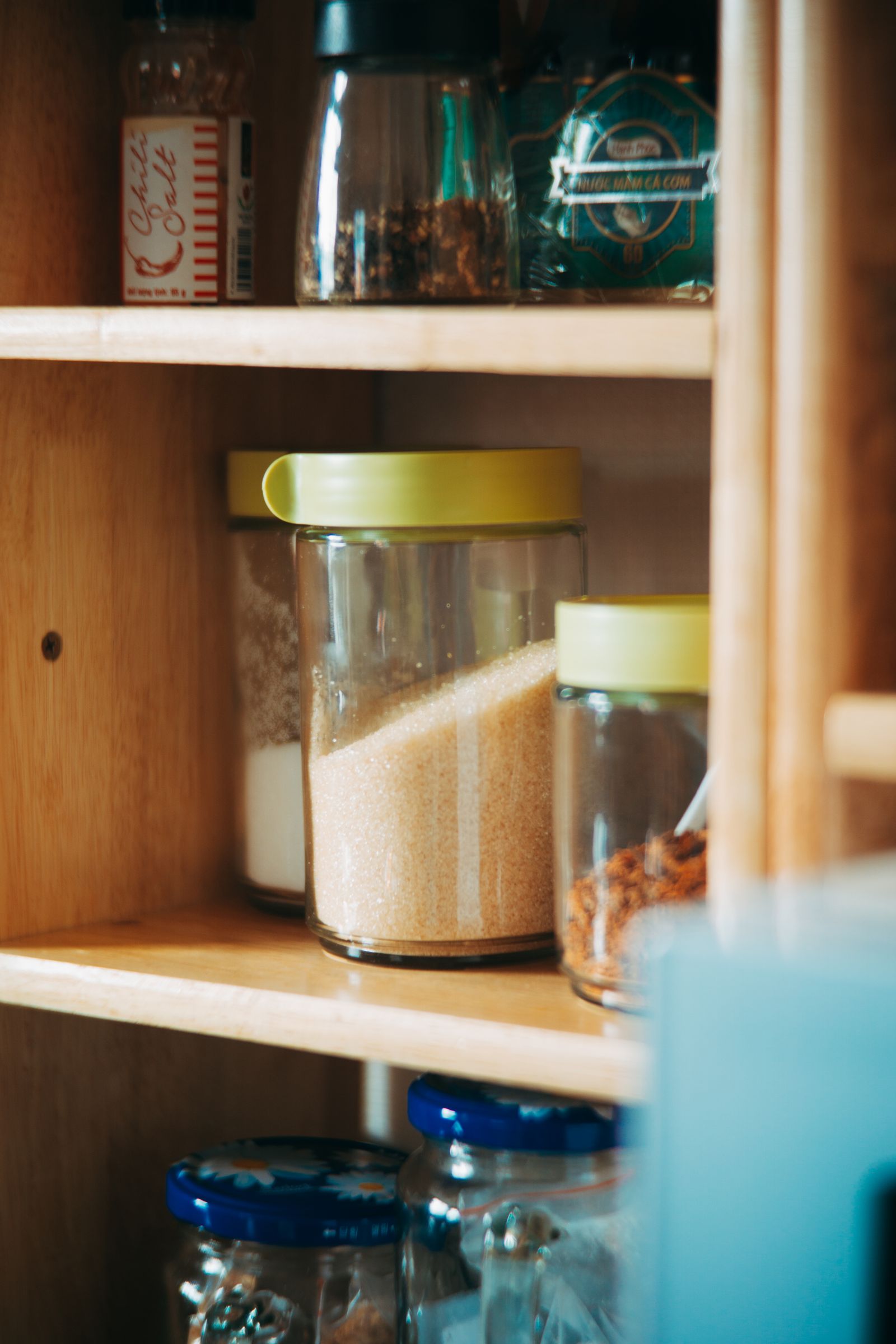 Neatly arranged jars on wooden pantry shelves