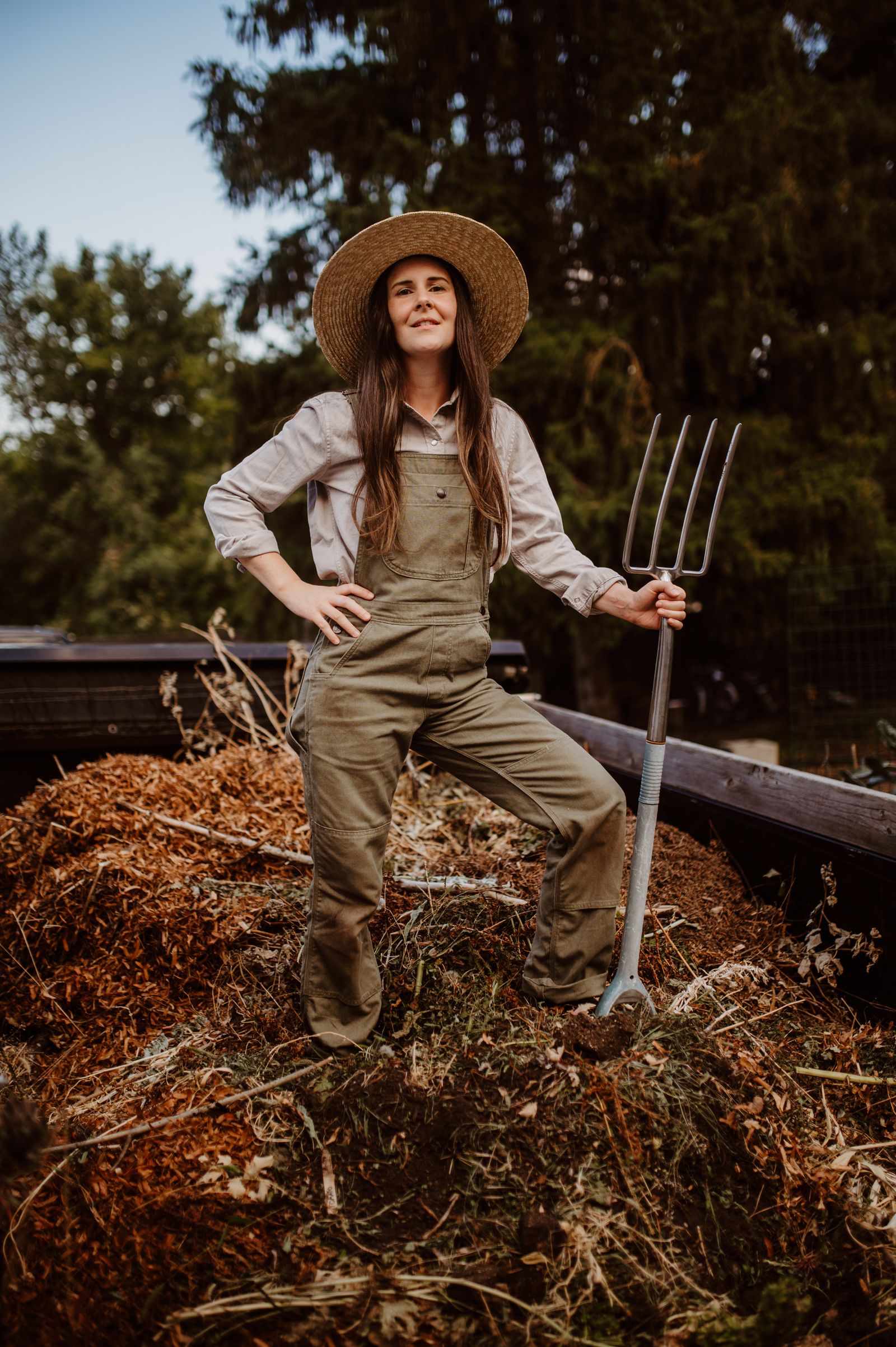 Gardener standing beside an outdoor compost pile